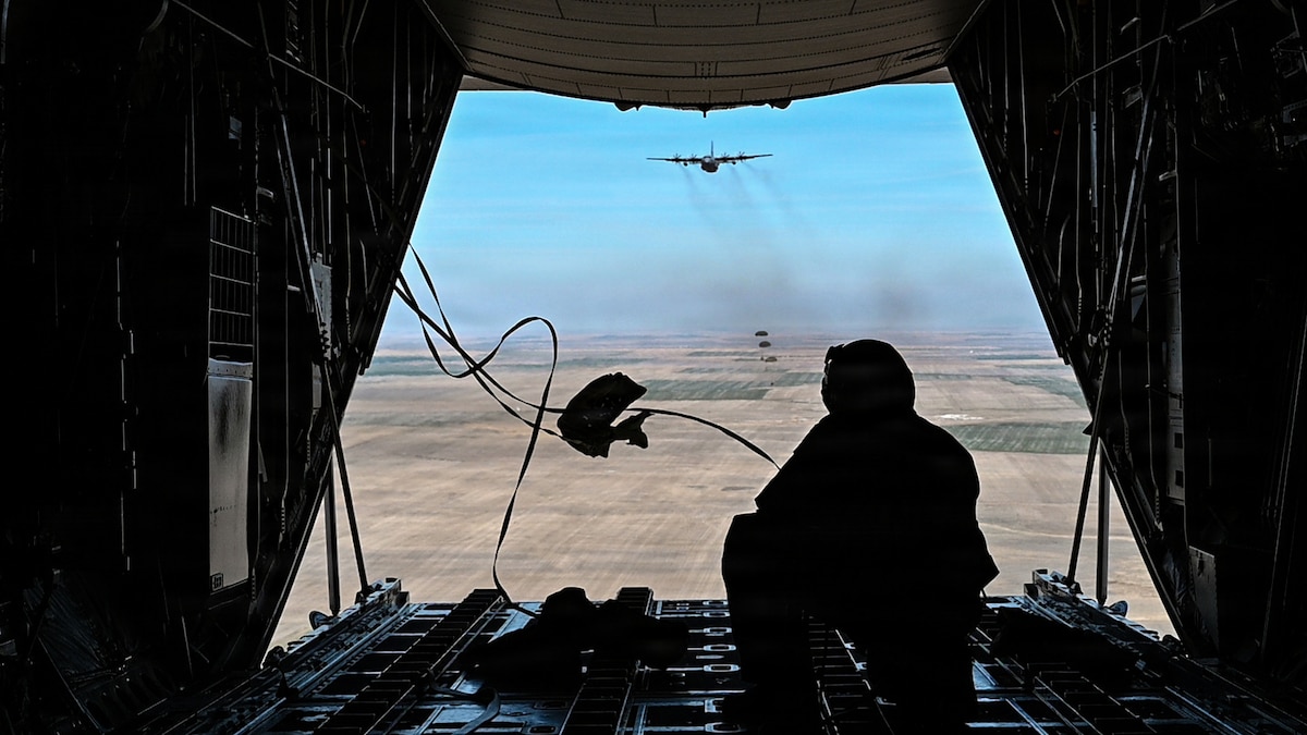 A U.S. Air Force loadmaster assigned to the 120th Airlift Wing observes cargo bundles descending over the Vigilante Drop Zone during an aerial delivery mission near Power, Mont., April 6, 2026. The training highlights the Montana Air National Guard’s ability to deliver critical supplies into remote environments where traditional airfields are unavailable. (U.S. Air National Guard photo by Senior Master Sgt. Devin Doskey)