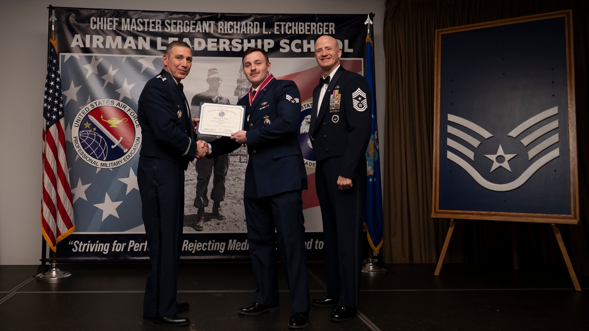A photo of airmen posing with an award