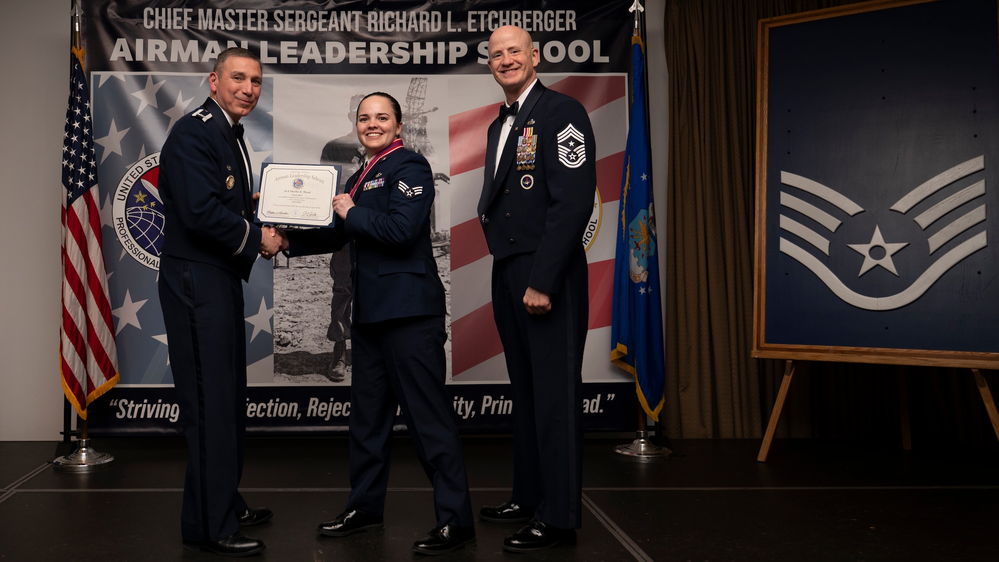 A photo of airmen posing with an award