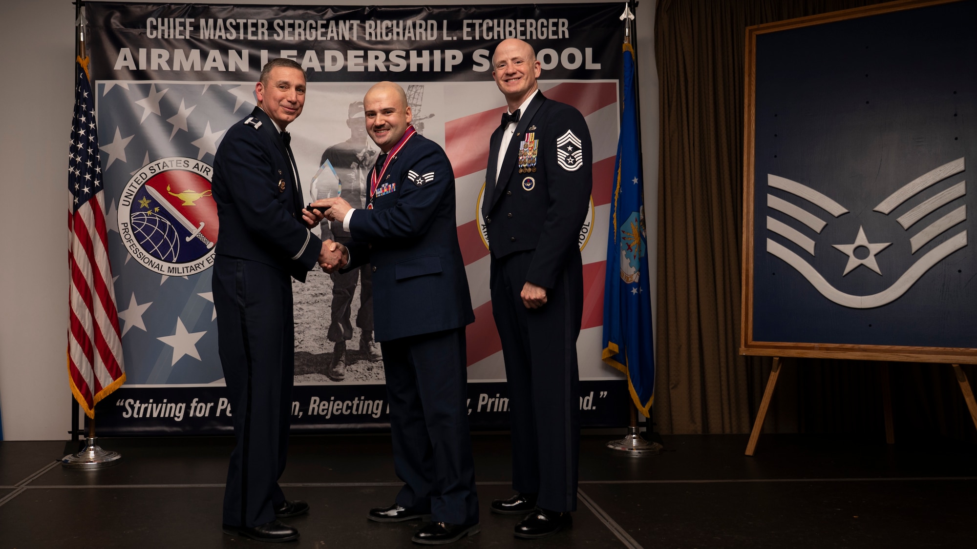 A photo of airmen posing with an award