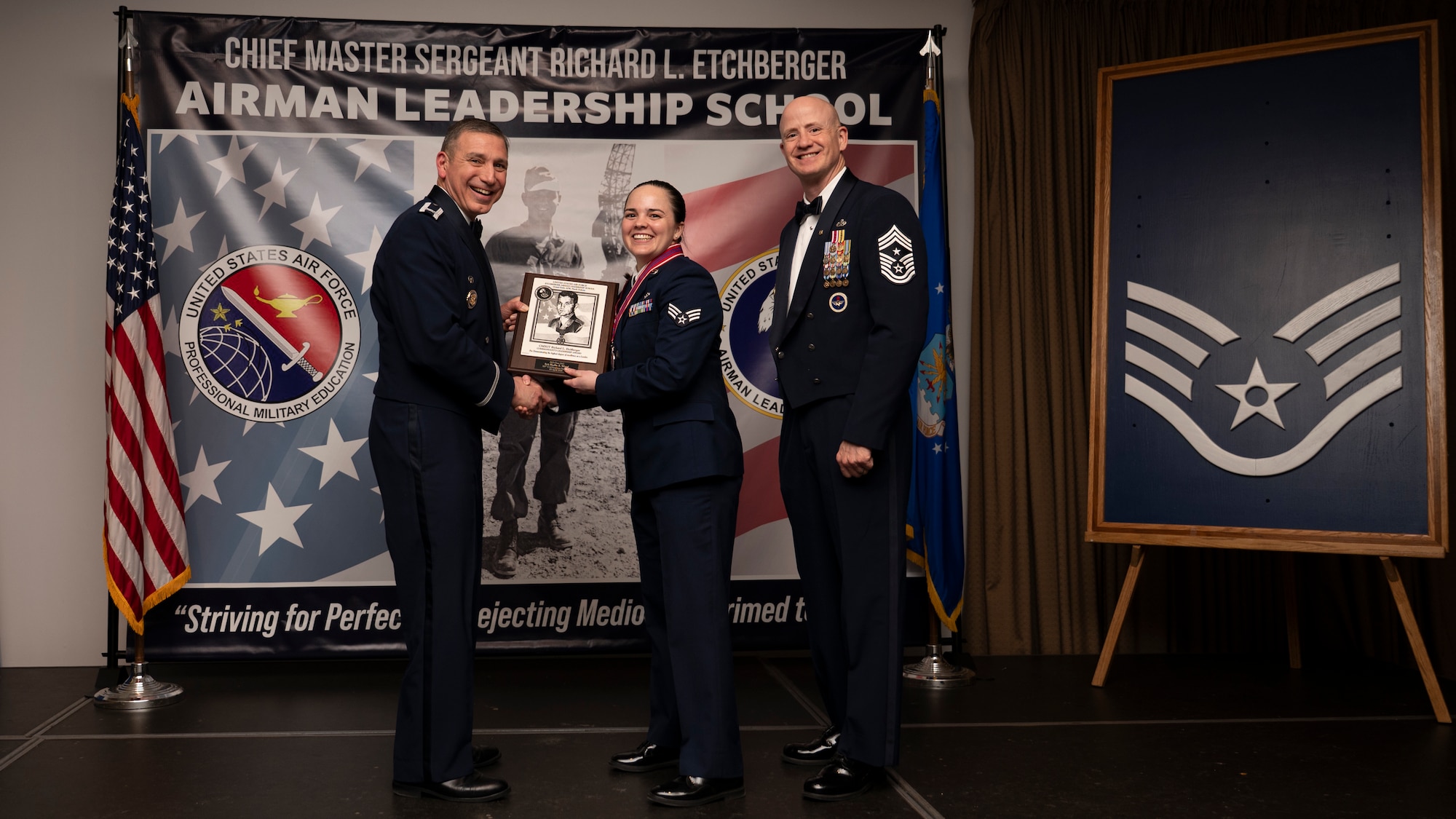 A photo of airmen posing with an award