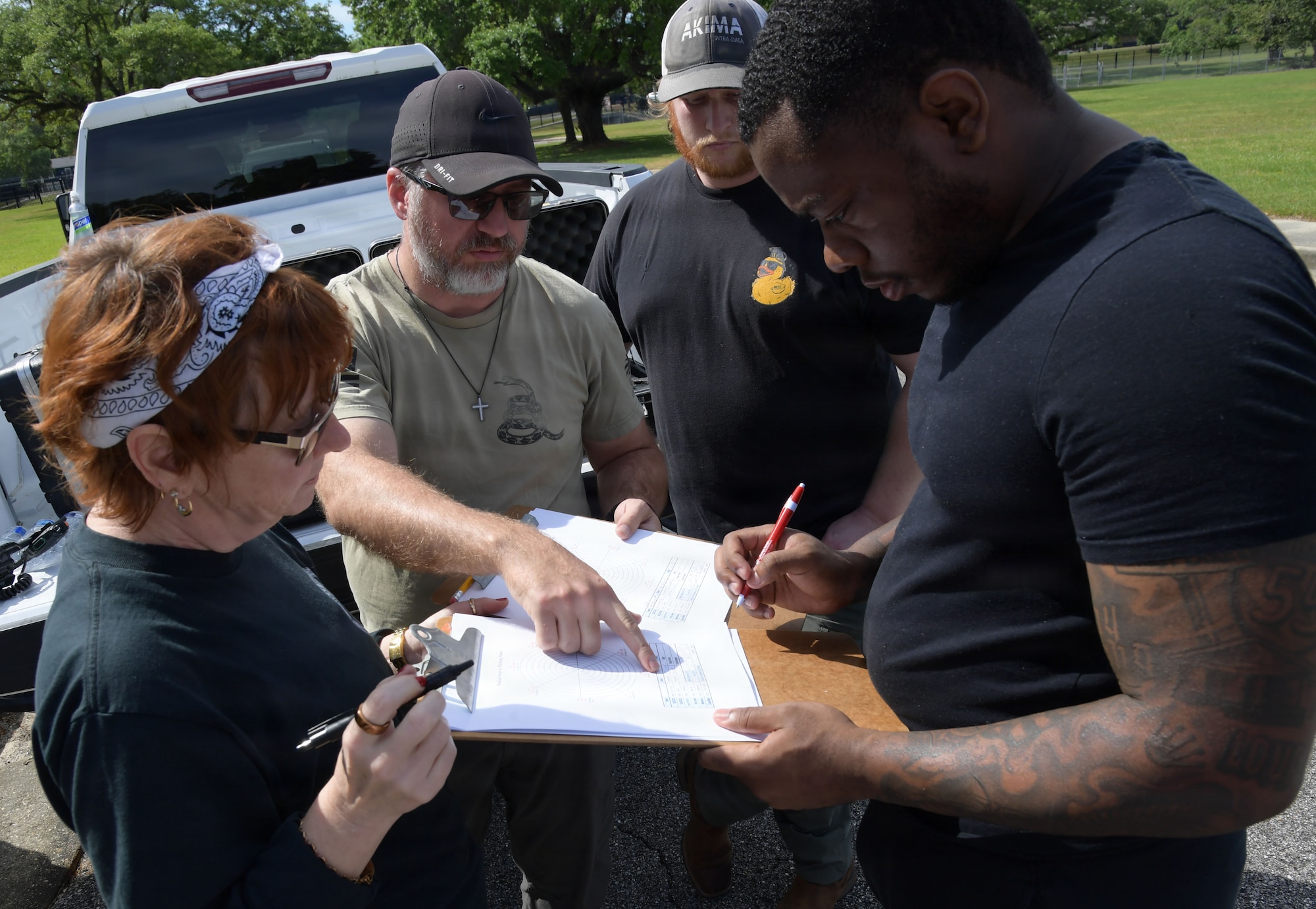A group of people gather around a chart while talking.