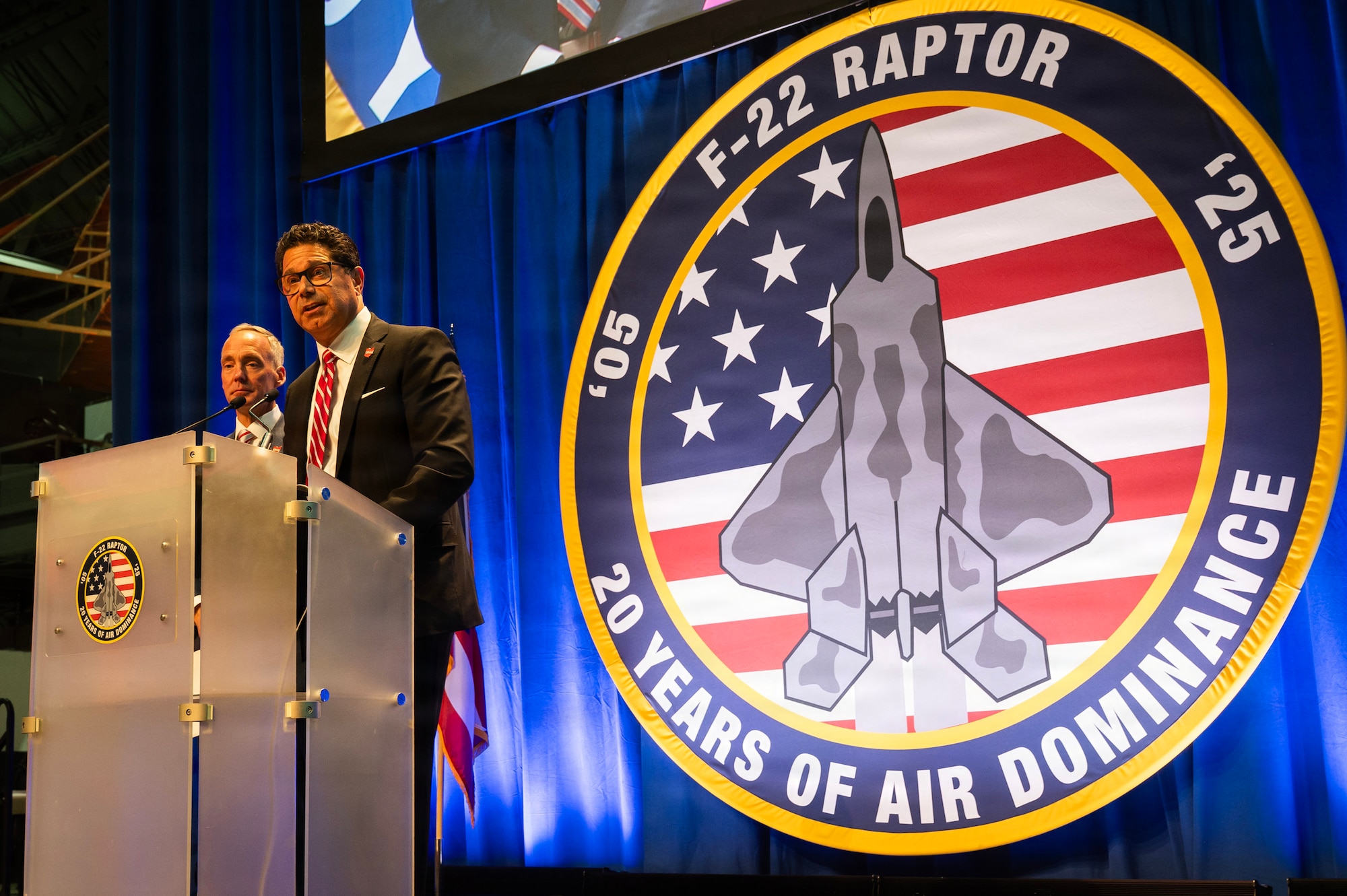Men on stage behind a podium.