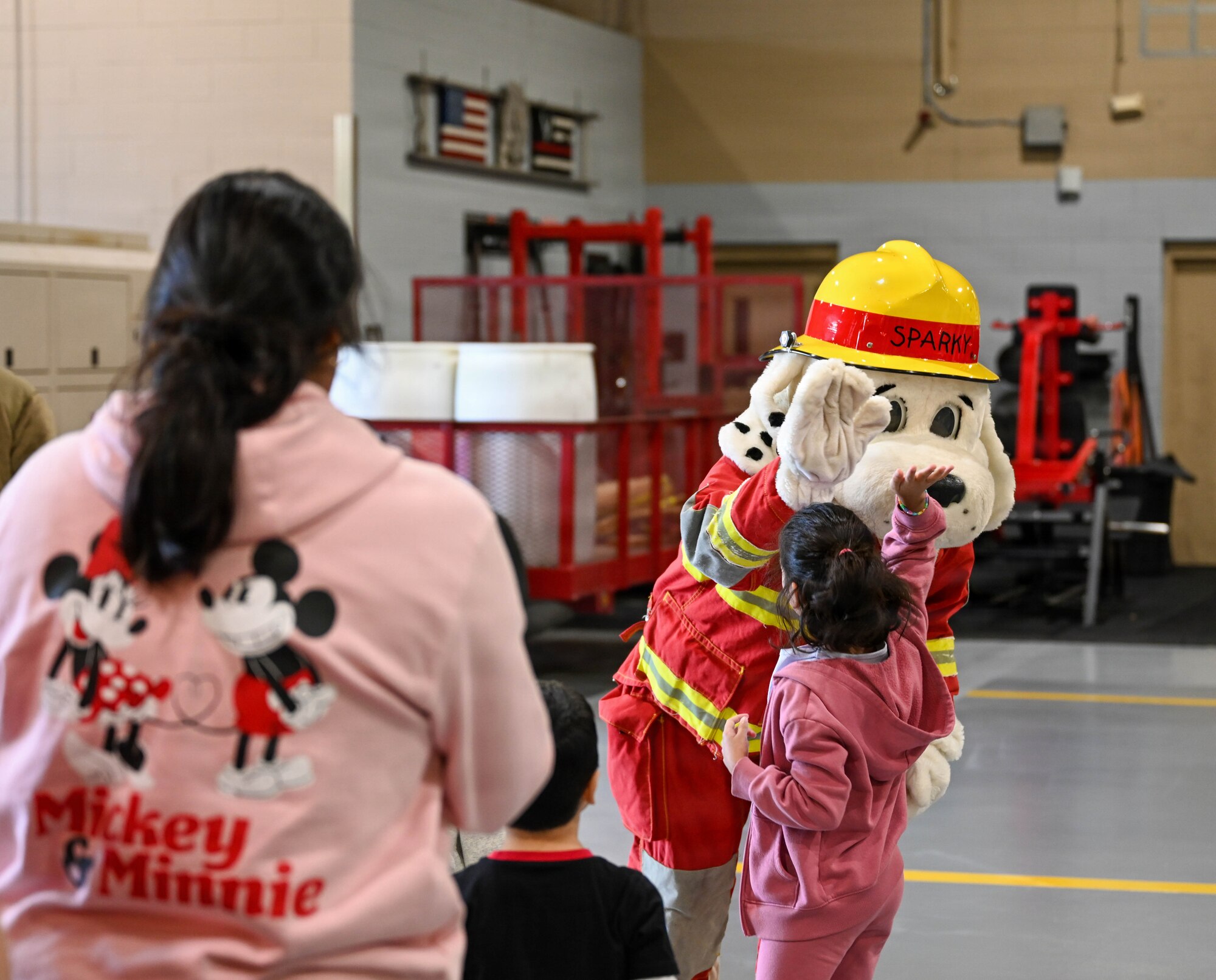A child high-fives Sparky the Fire Dog