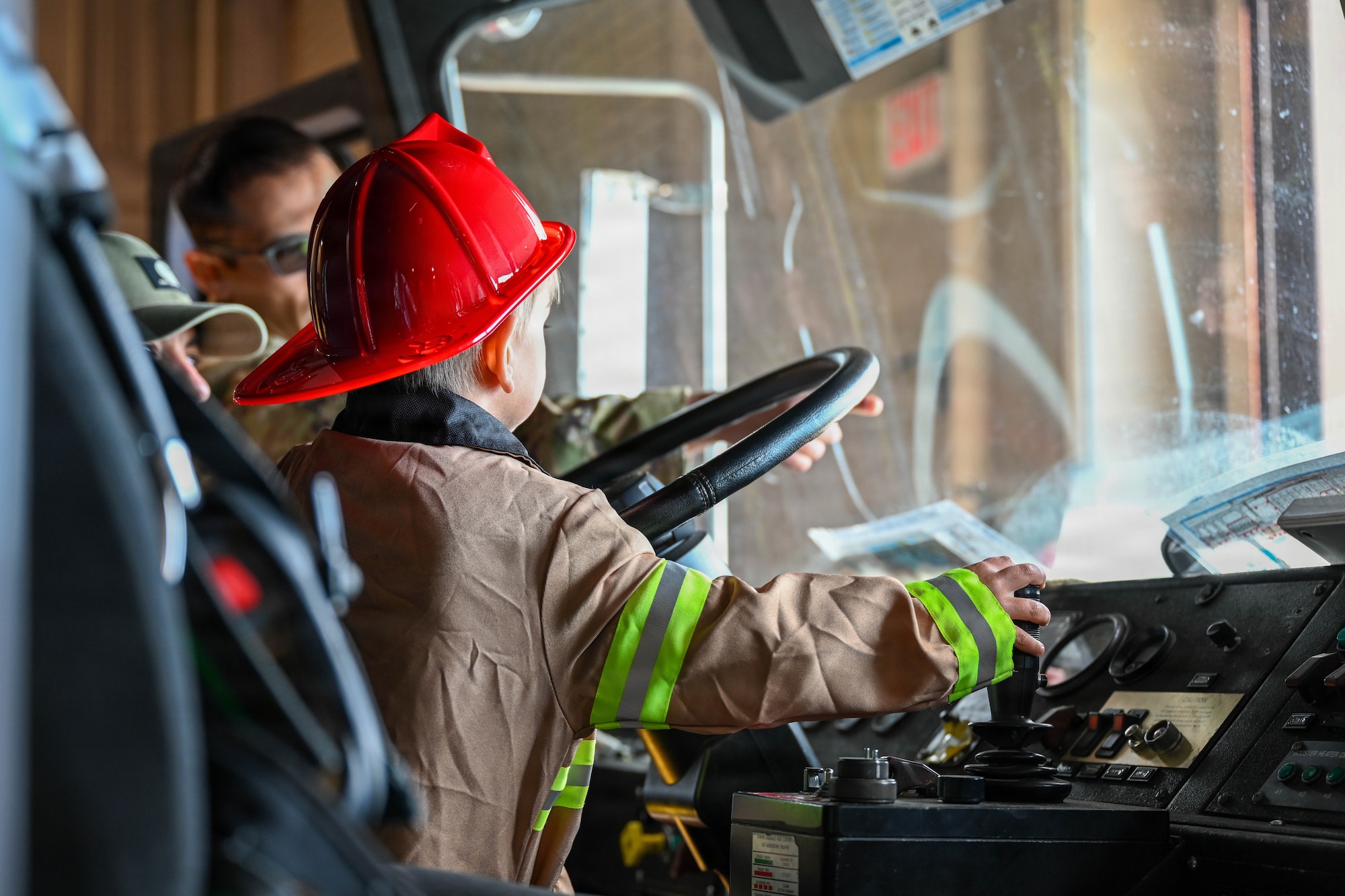 A child operates controls on a firetruck