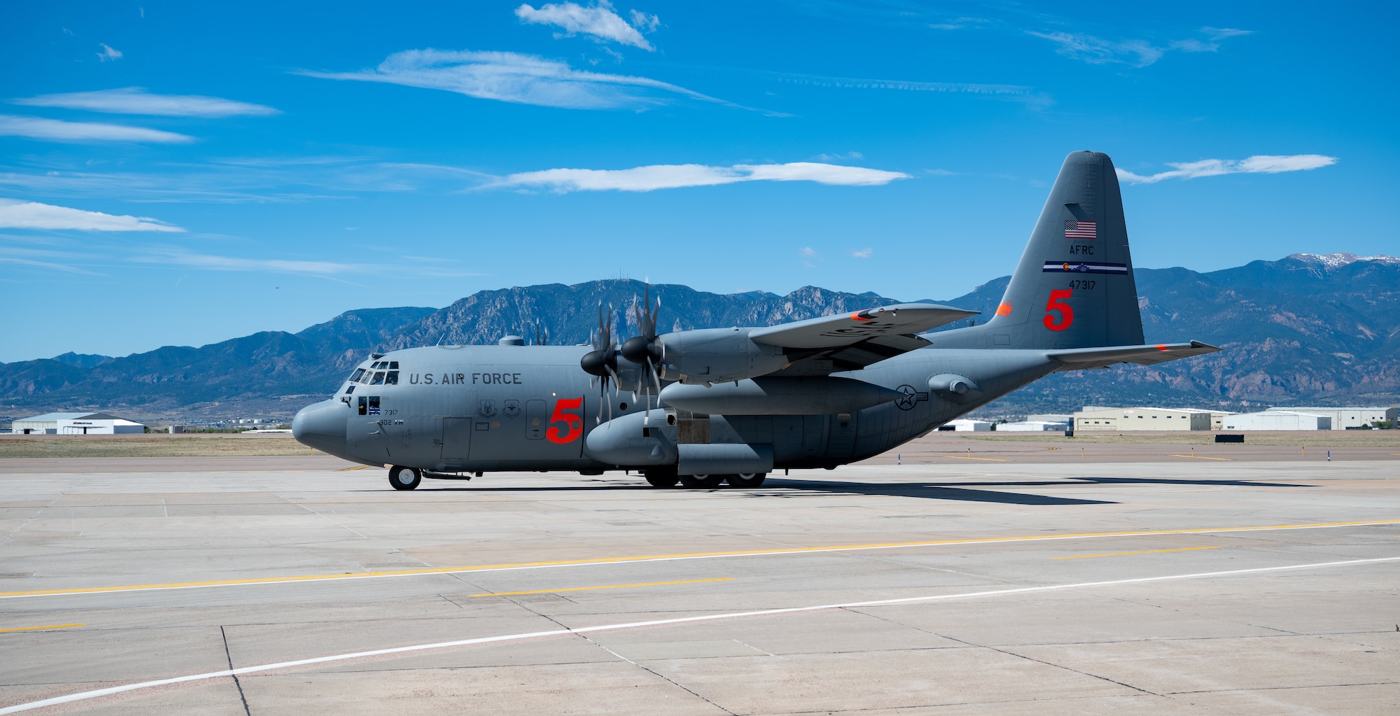 A C-130H Hercules aircraft idles on a runway.