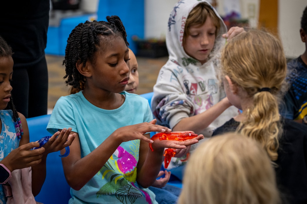 Kids play with rubber alligator.