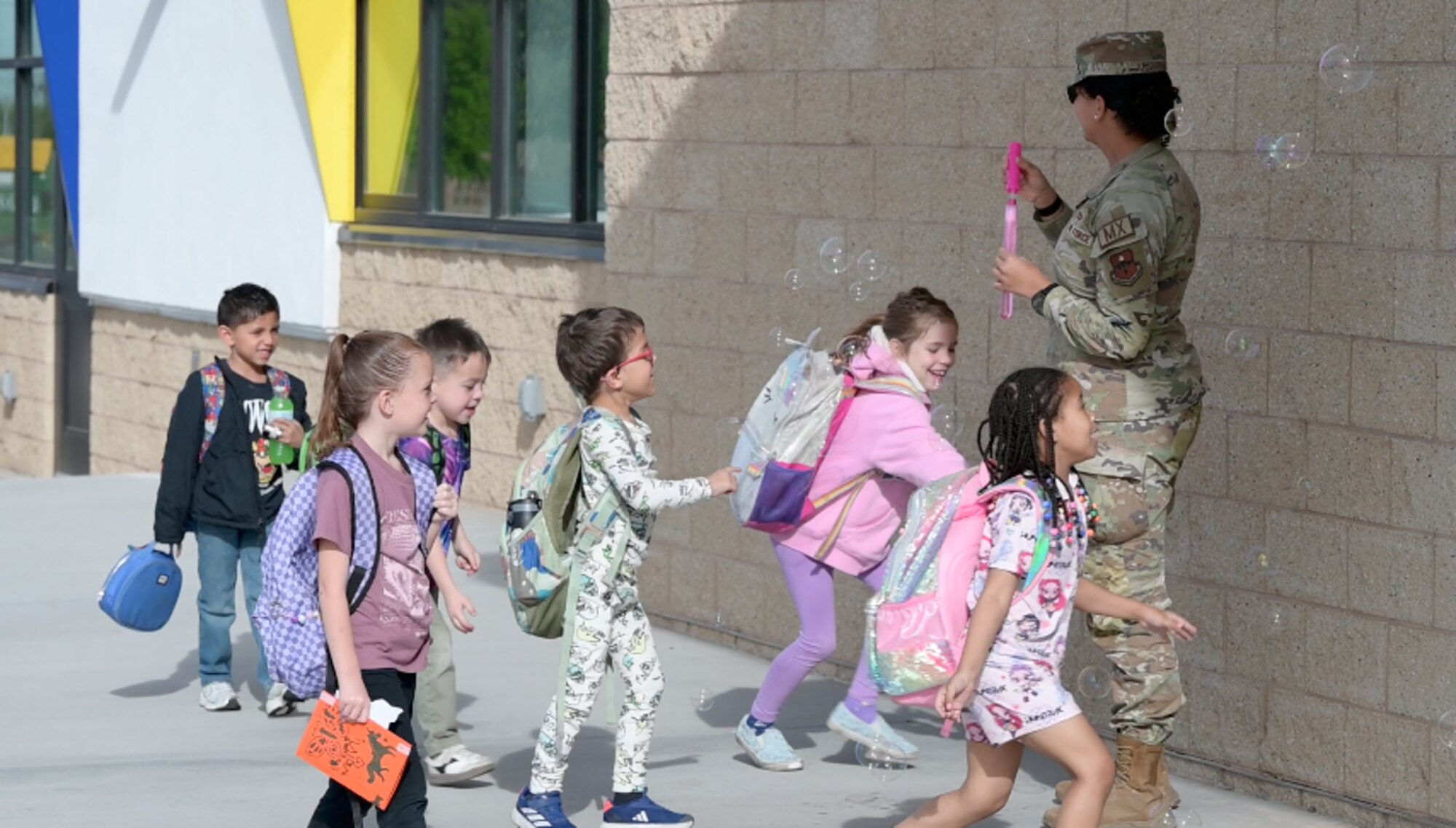 Students from Sandia Base Elementary School play with bubbles blown by service-members April 10 at Kirtland Air Force Base, New Mexico. The event was held as part of a month-long celebration honoring the unique sacrifices and adaptability of military children across the base. (U.S. Air Force photo by Airman Maurice Casilla)