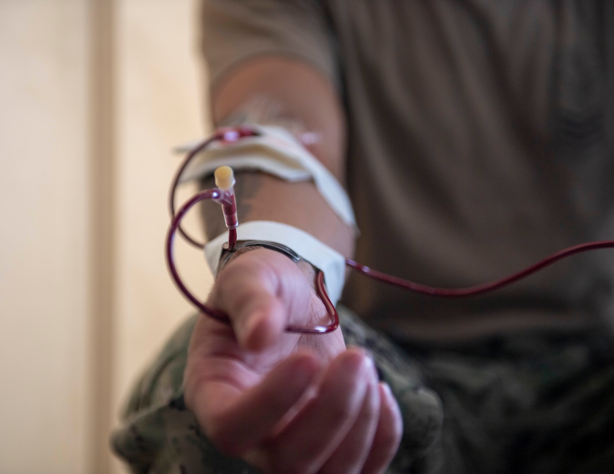 U.S. Navy Hospital Corpsman 1st Class Eric Adams, from Wildomar, California, performs a blood transfusion in a hangar bay onboard Marine Corps Base Kaneohe Bay, Oahu, Hawaii, in support of a joint-service medical training exercise during Rim of the Pacific (RIMPAC) 2022, July 26, 2022.