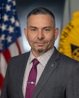 Retired Sgt. 1st Class Carlos Arguello, U.S. Army Financial Management Command Army contract and commercial pay vendor action officer, poses for a photo at the Maj. Gen. Emmett J. Bean Federal Center in Indianapolis June 2, 2025. In 2005, while deployed with the 106th Financial Support Unit, Arguello drew the artwork “There’ll be a Finance Soldier Close at Hand.” (U.S. Army photo by Mark R. W. Orders-Woempner)