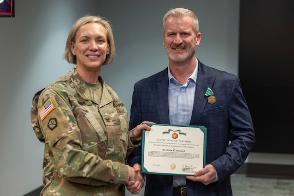 Col. Michelle M. Williams, U.S. Army Financial Management Command commander, presents Stede M. Harwood, USAFMCOM Army Financial Services financial management systems analyst, with a U.S. Army civilian service commendation medal during a town hall at the Maj. Gen. Emmett J. Bean Federal Center Jan. 12, 2026. Harwood was presented the medal on behalf of Lt. Gen. Christopher M. Mohan, U.S. Army Materiel Command deputy commanding general and acting commander, for being recognized as an AMC employee of the quarter for the first quarter of Fiscal Year 2025. (U.S. Army photo by Mark R. W. Orders-Woempner)