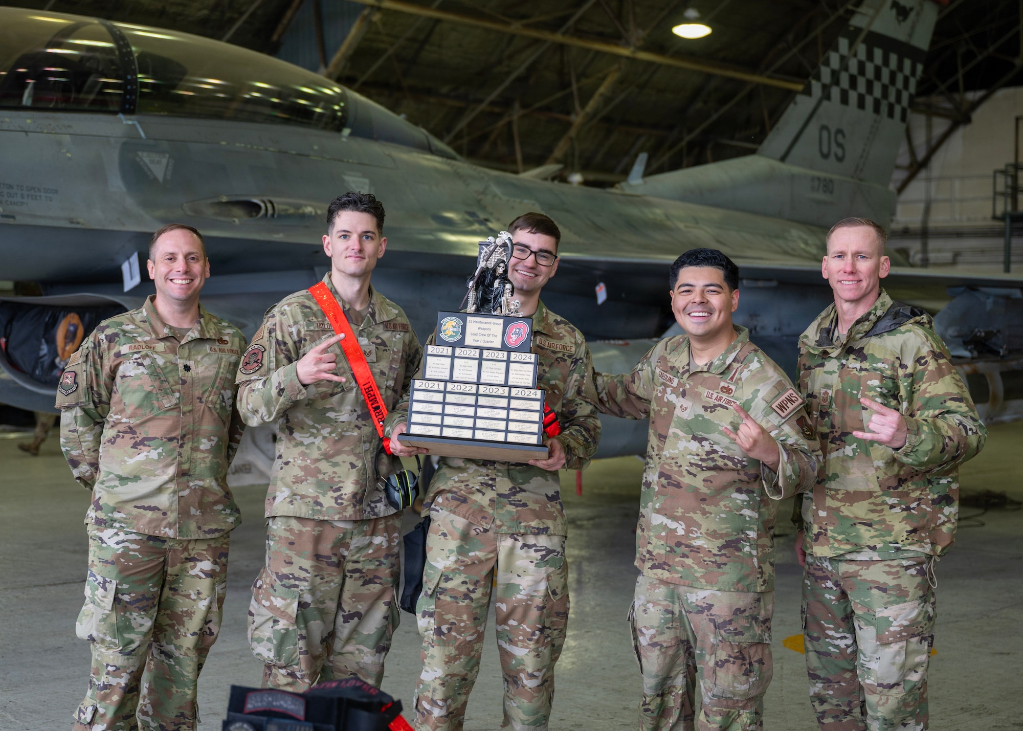 U.S. Air Force Airmen assigned to the 51st Munitions Squadron pose for a group photo after winning the 1st Quarter Ammo Bomb Building and Loading Competition at Osan Air Base, Republic of Korea, April, 9, 2026. The competition tested the technical accuracy, adherence to safety protocols, team coordination, and loading time of the weapons load crews as they loaded munitions onto F-16 Fighting Falcons. (U.S. Air Force photo by Staff Sgt. Sarah Williams)
