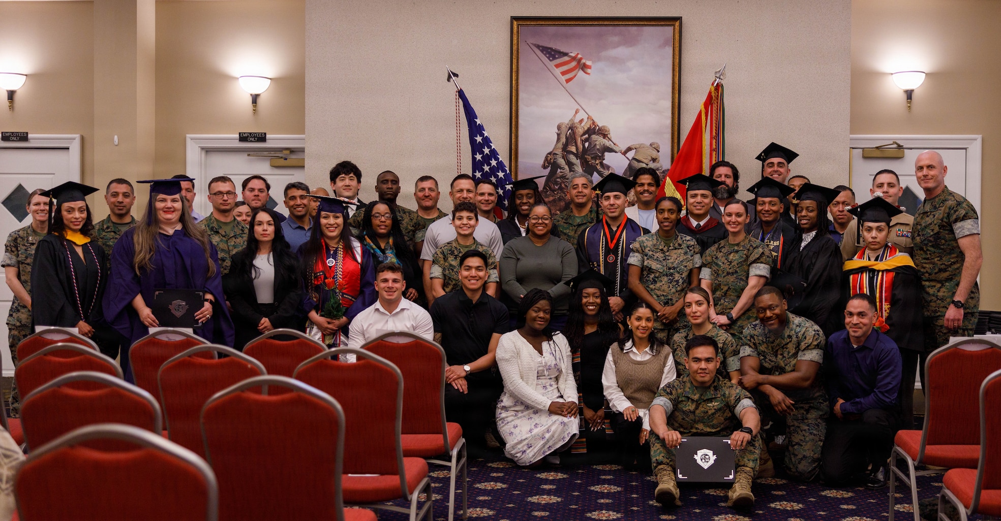 U.S. Marine Corps Col. Jenny Colegate, the commanding officer of Marine Corps Base Quantico and Sgt. Maj. Liam Williams, the sergeant major of MCB Quantico, pose for a group photo with the graduates for the Student Success Celebration Ceremony at The Clubs of Quantico on MCB Quantico, Virginia, April 7, 2026. The Voluntary Education Center recognizes active-duty service members, veterans, and Department of War civilians aboard MCB Quantico who have achieved degree completion at any level, certification, or license. (U.S. Marine Corps photo by Lance Cpl. Lynsee Avila-Ramirez)