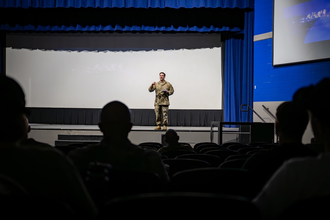 Man addresses an audience from the stage.