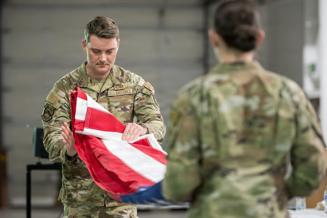 Honor Guardsmen demonstrate the folding of a United States flag.