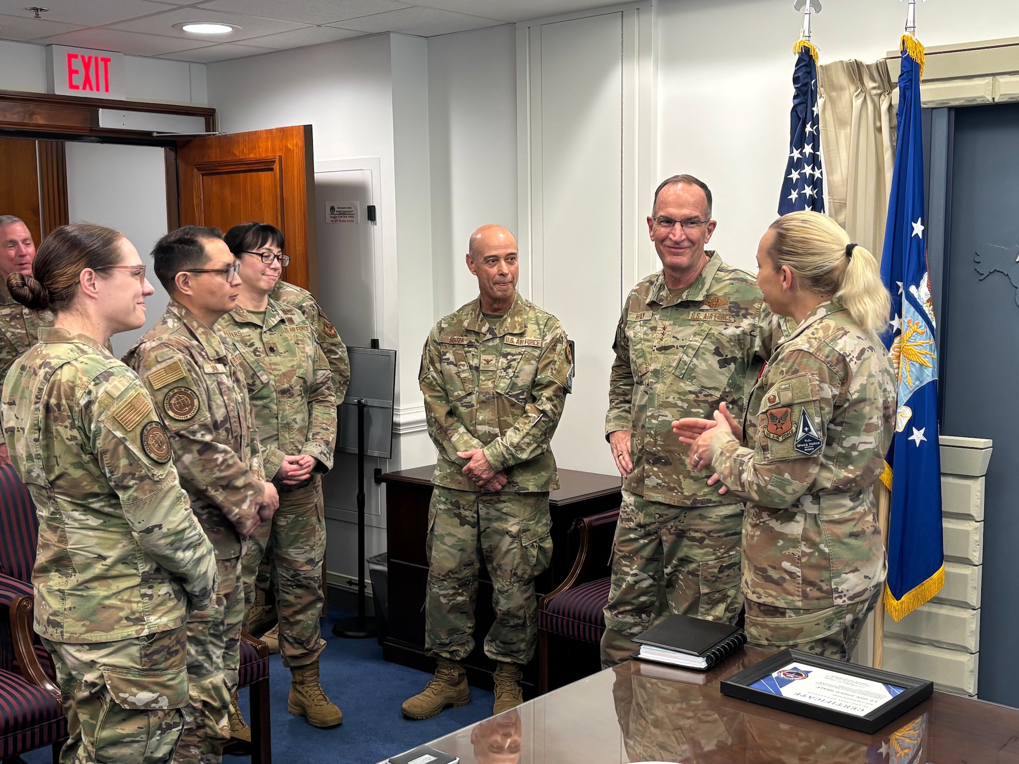 A group of Air Force members standing in a circle talking.