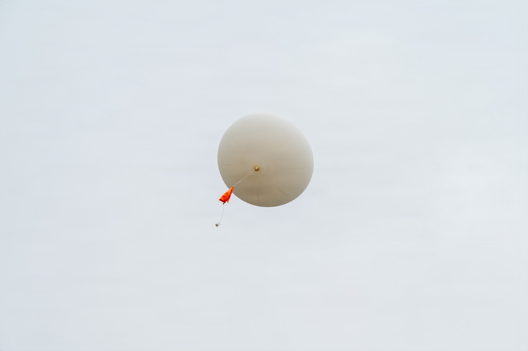 A weather balloon ascends into the sky.
