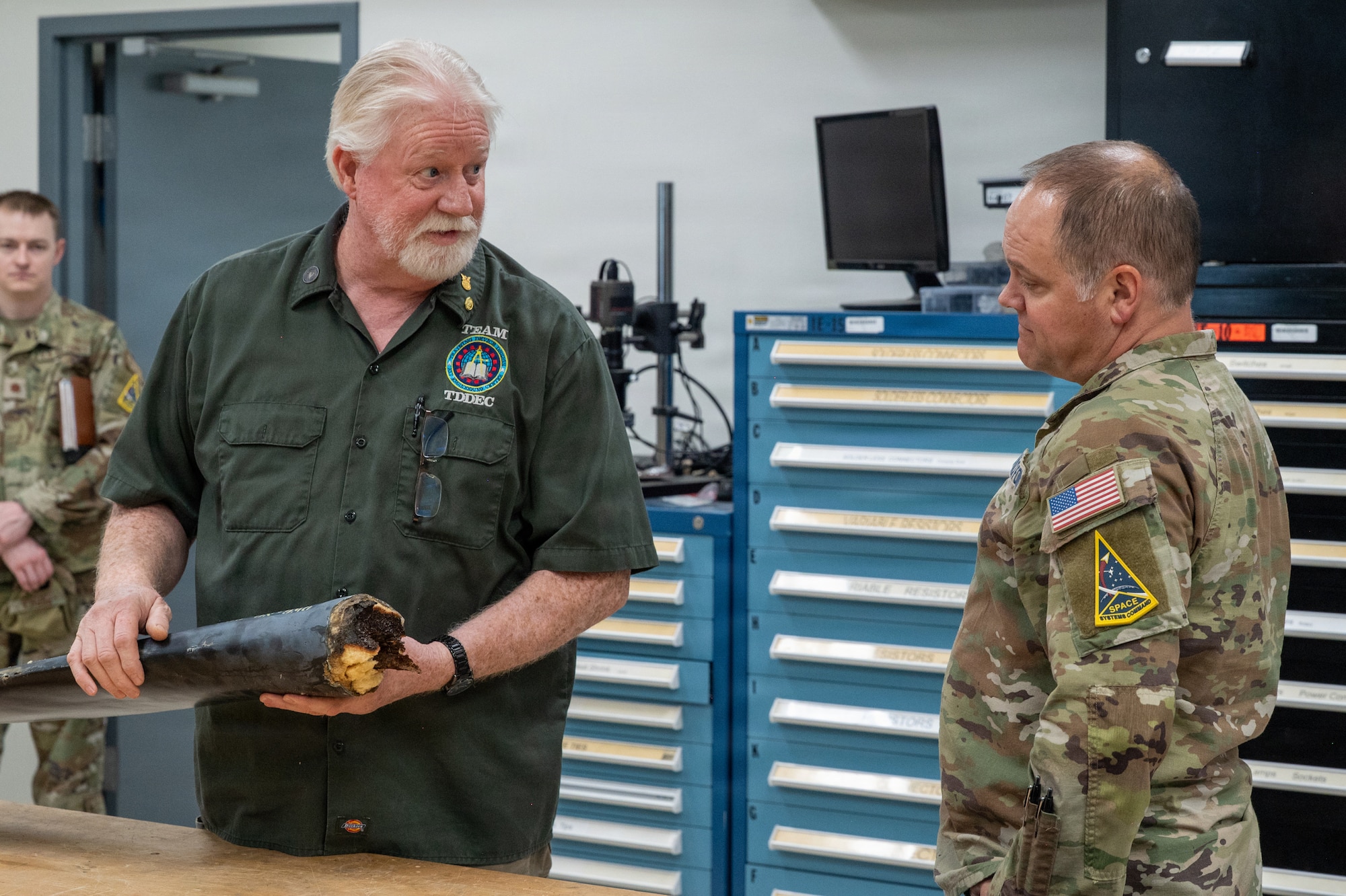 U.S. Space Force Col. James T. Horne III, right, Space Launch Delta 30 commander, and Joaquin Tinker, left, Training Device Design and Engineering Center director, stand near each other and engage in conversation.
