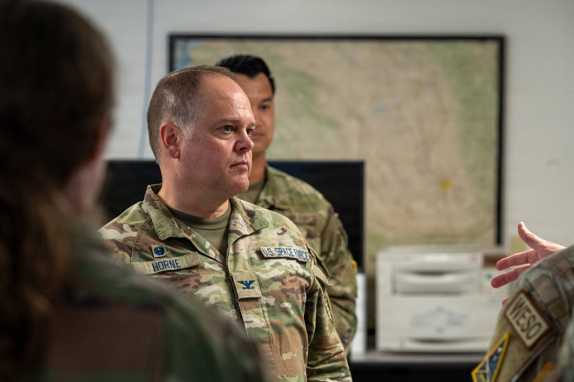 U.S. Space Force Col. James T. Horne III, Space Launch Delta 30 commander, stands and listens to a briefing.