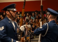 Students watch from gymnasium bleachers as the drill team performs.