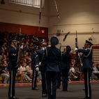 Four Airmen are shown tossing rifles overhead.