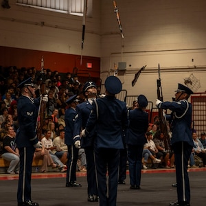 Four Airmen are shown tossing rifles overhead.