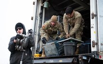 Airmen download equipment from a truck.