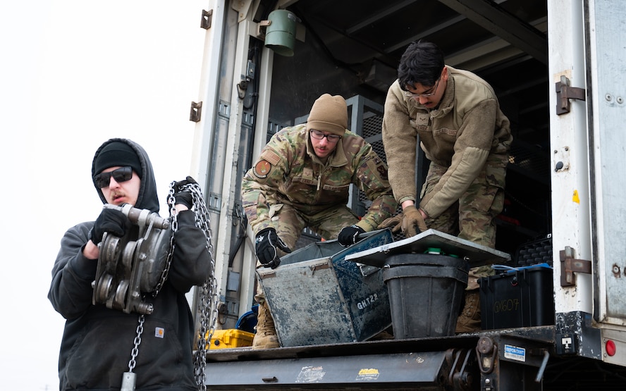 Airmen download equipment from a truck.