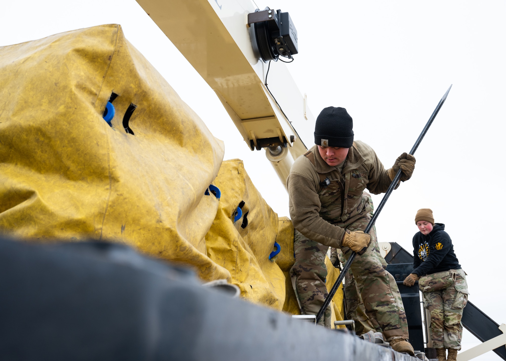 An Airman pries loose chain links holding replacement batteries for a launch facility.