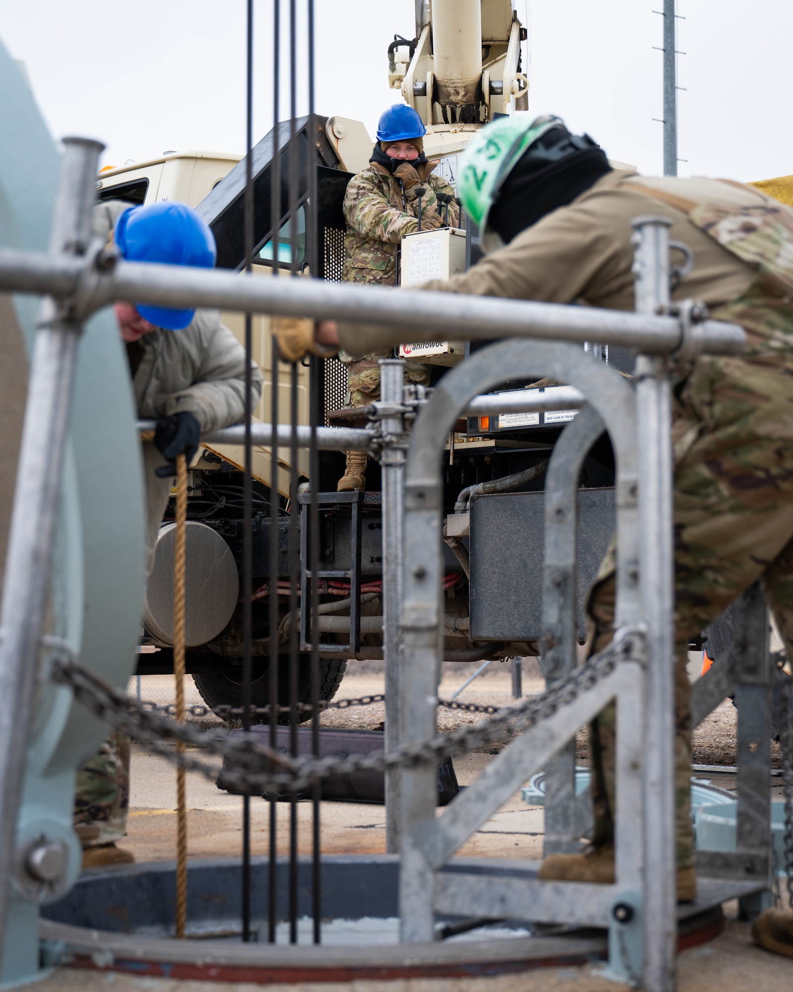 An Airman uses a crane to lower a replacement battery into a launch facility.