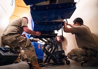 Airmen replace batteries within a launch facility.