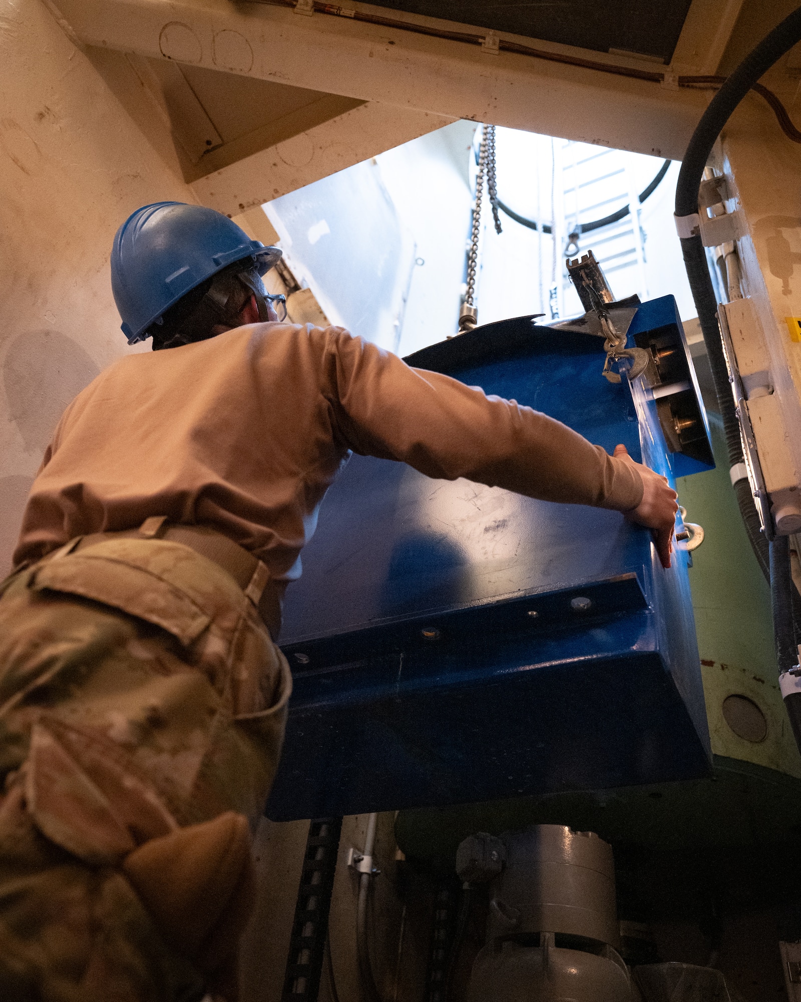 An Airman lowers a battery into a launch facility.