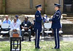 Two men in military uniforms fold a U.S. flag.
