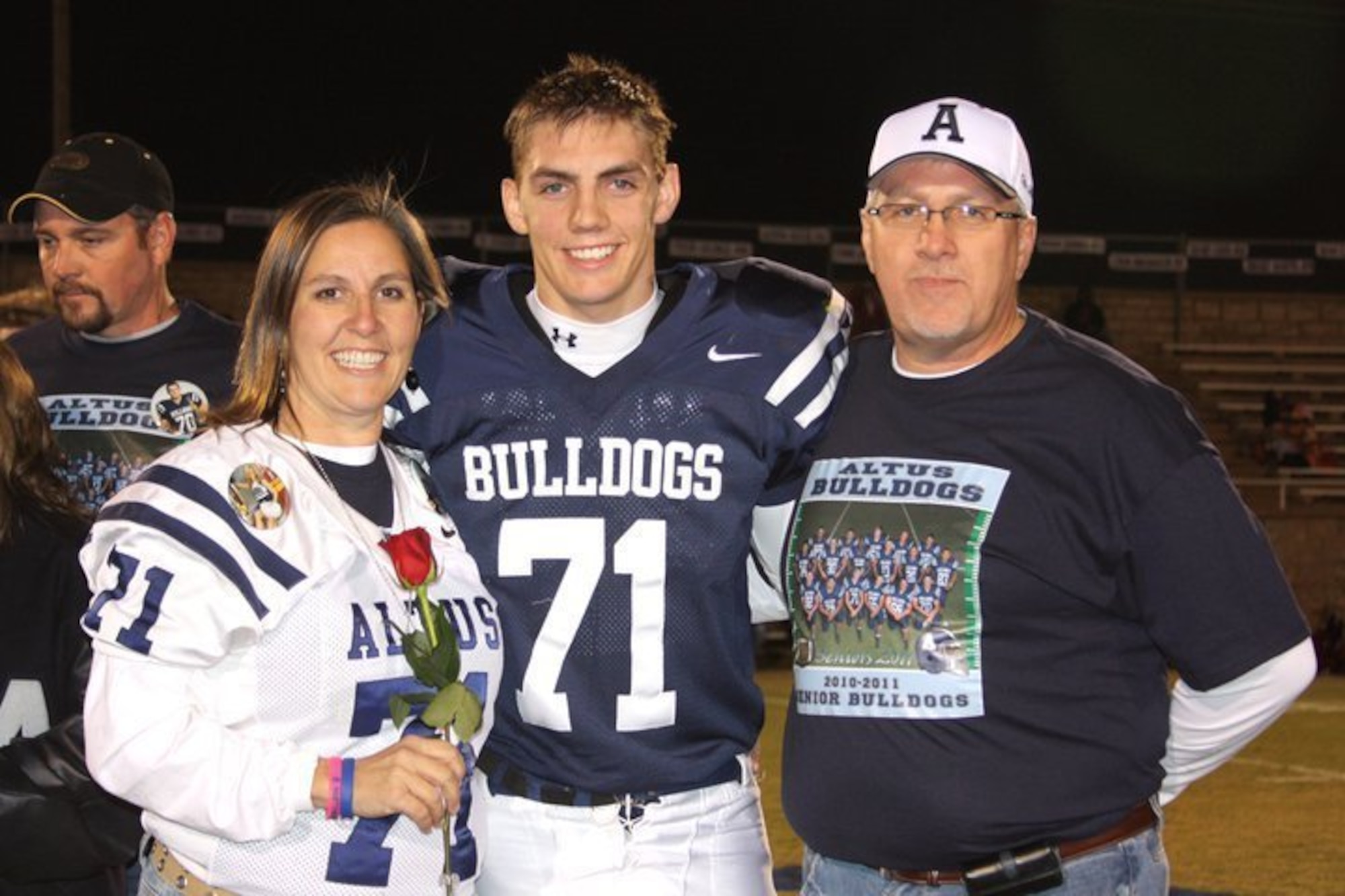 Jeremy Delzer poses for a photo with his parents, Jaretta and Scott Delzer, at the Altus High School football stadium, Altus, Oklahoma, Nov. 16, 2010. Since graduating in 2011, Delzer has returned to Altus to serve as a U.S. Air Force KC-46 Pegasus aircraft instructor pilot and demo team lead. (Courtesy photo)