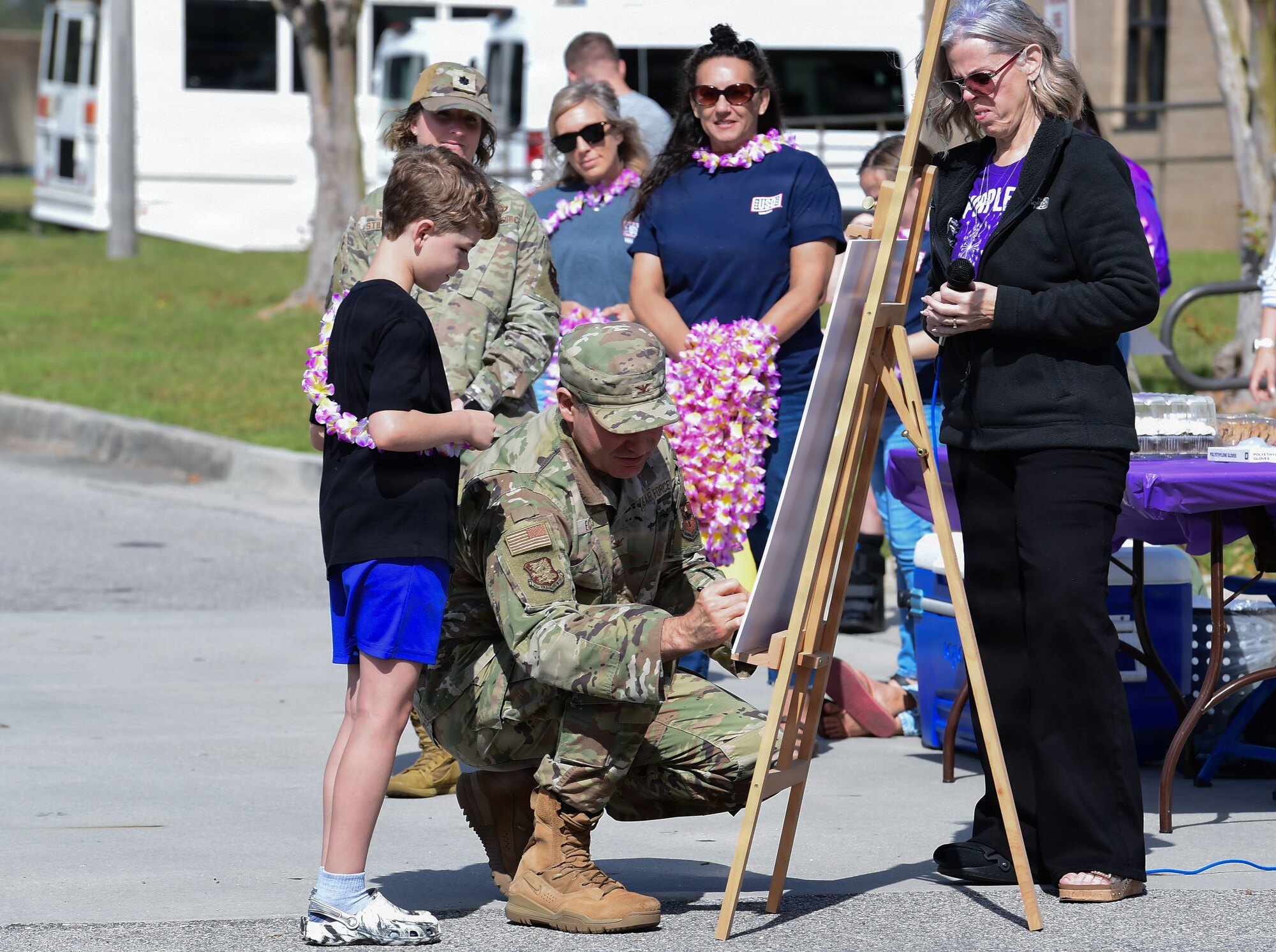A man in military uniform signs a proclamation.