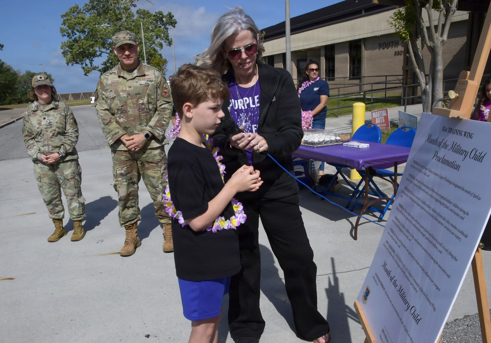 A young boy reads a proclamation.