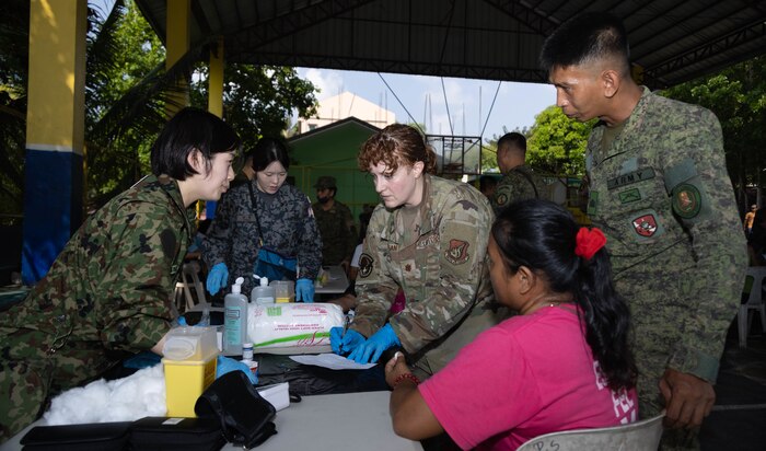 Japan Ground Self-Defense Force, Capt. Murata Emiko, left, a nurse with the Japan Self-Defense Forces, U.S. Air Force Maj. Lindsey T. Colgan, center, a registered dietitian with the Combined Joint Civil-Military Operations Task Force, and Philippine Army Sgt. Gilbert Concepcion, an infantryman with 304th Community Defense Center, medically screen Rachelle Santos during Exercise Balikatan 25 at the Pulong Sampaloc Barangay Hall, Dona Remedios Trinidad, Bulacan, April 23, 2025.