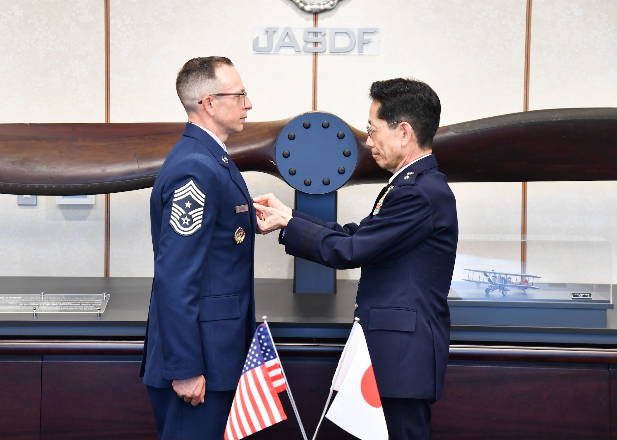 U.S. Air Force Chief Master Sergeant Shaun Campbell and Japan Air Self-Defense Force Gen Takehiro Morita pose for a photo at the Ministry of Defense Tokyo, Japan, April 10, 2026. Campbell received the Certificate of Appreciation, Japan Defense Cooperation Award 2nd Class for his contributions to strengthening the relationship and interoperability between between Koku-Jieitai (Japan Air Self-Defense Force) and the United States Air Force.