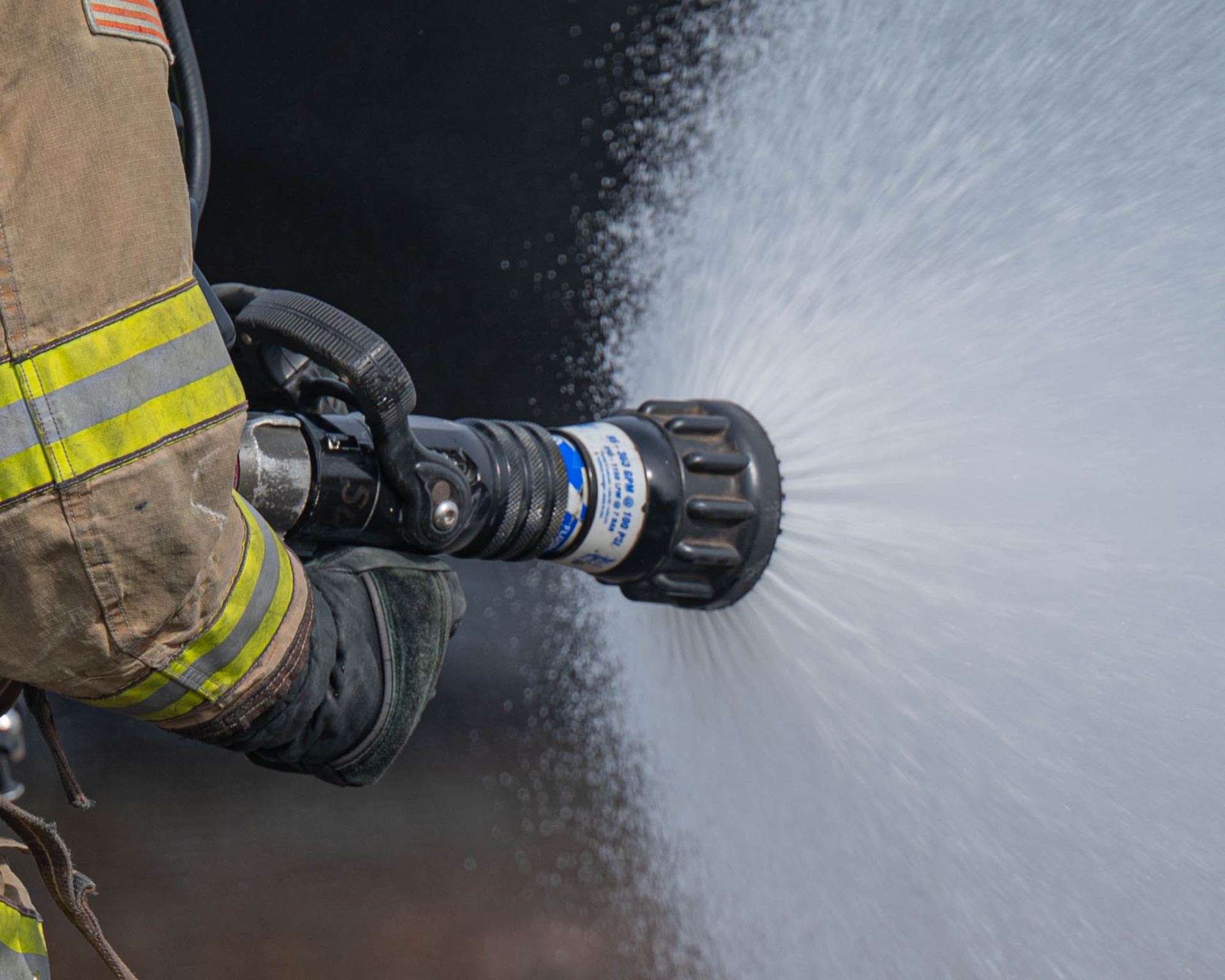 A member of the Altus Air Force Base (AFB) Fire Department operates a water hose during a live fire training exercise at Altus Air Force Base, Oklahoma, April 7, 2026. Members of the Altus AFB Fire Department and Lawton Fire Department conducted aircraft live fire evolutions in a joint training exercise. (U.S. Air Force photo by Airman 1st Class Emma Wright)