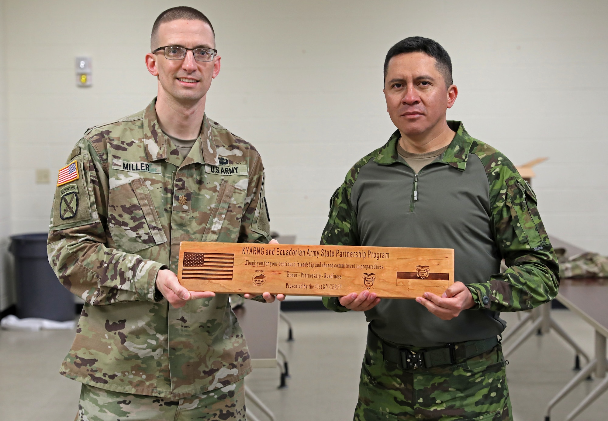 U.S. Army Maj. Thomas Miller, the Kentucky National Guard’s Chemical, Biological, Radiological, Nuclear and high-yield Explosive Enhanced Response Force Package officer in charge, presents Ecuadorian Army Maj. Oswaldo Barreto with a wooden stave as a gift of gratitude during a State Partnership Program visit with the Kentucky Guard’s 103rd Chemical Battalion at the unit’s readiness center in Burlington, Ky., March 12, 2026. The visit provided an opportunity for partner forces to exchange knowledge, strengthen professional relationships, and enhance cooperation between the two militaries. (U.S. Army National Guard photo by Sgt. 1st Class Benjamin Crane)