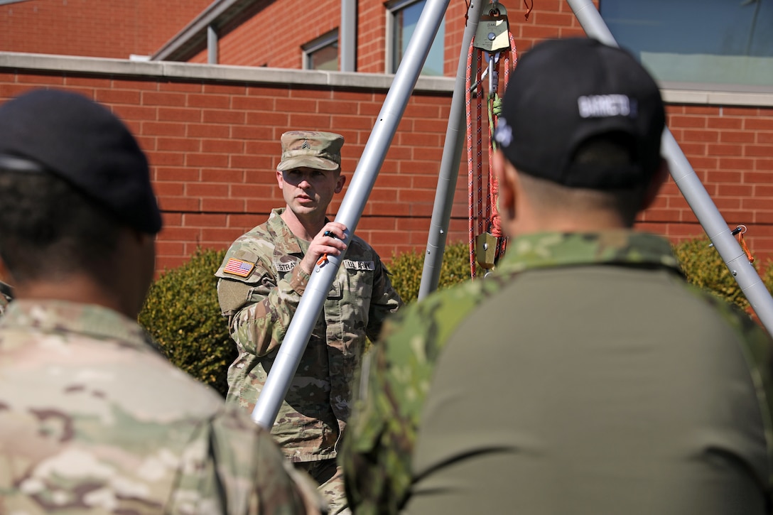 U.S. Army Sgt. Andrew Stratton, a non-commissioned officer with the Kentucky National Guard’s Chemical, Biological, Radiological, Nuclear and high-yield Explosive Enhanced Response Force Package,  gives a rescue demonstration on the extract element cradle system to soldiers with the Ecuadorian Army during their State Partnership Program visit with the Kentucky Army National Guard’s 103rd Chemical Battalion at the unit’s readiness center in Burlington, Ky., March 12, 2026. The visit provided an opportunity for partner forces to exchange knowledge, strengthen professional relationships, and enhance cooperation between the two militaries. (U.S. Army National Guard photo by Sgt. 1st Class Benjamin Crane)