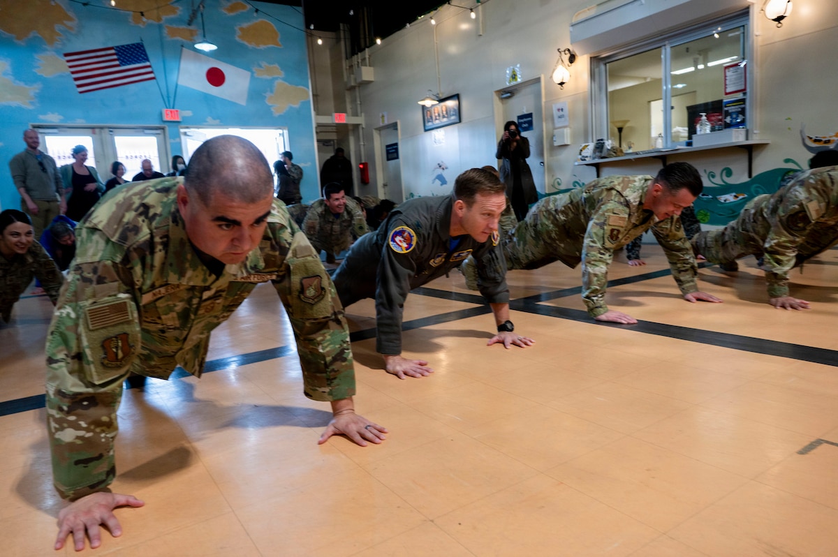 35th Fighter Wing leaders and members of the Misawa community perform push-ups before entering the Bushido Fitness Center during its grand opening at Misawa Air Base, Japan, April 10, 2026. The event highlighted the importance of physical fitness and readiness across the installation. (U.S. Air Force photo by Senior Airman Gavin Hameed)