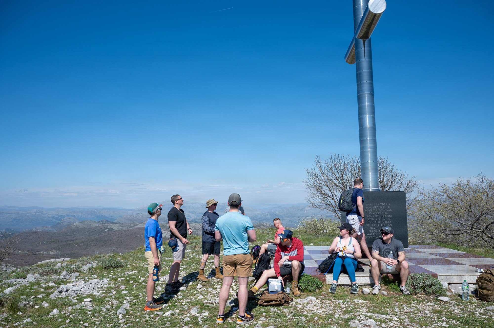People rest near a memorial on a mountain