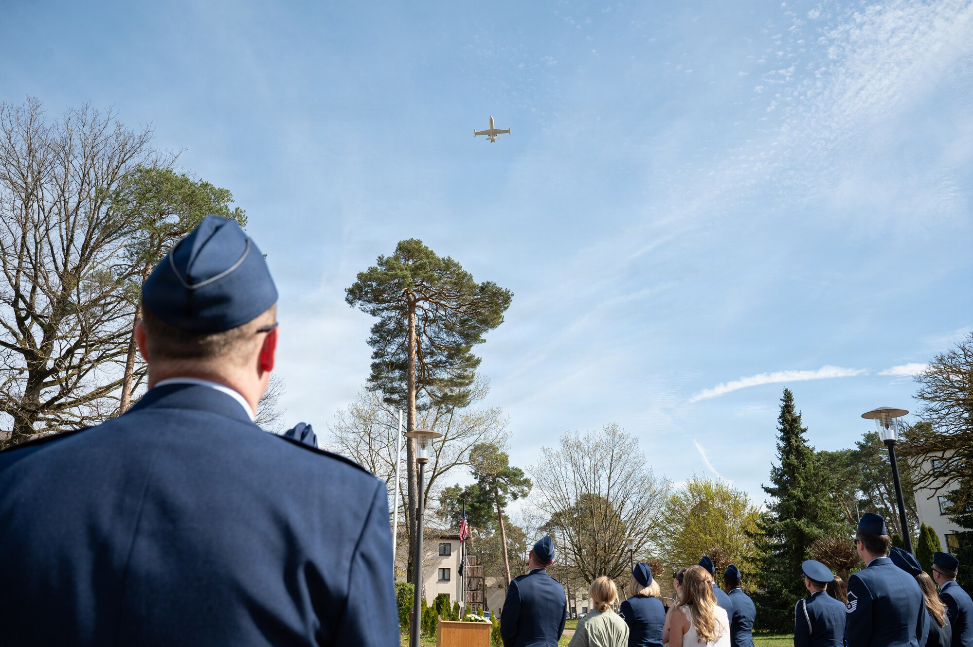 People watch a flyover during a memorial