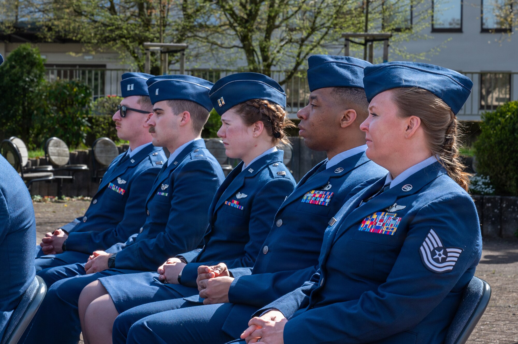 People sit in chairs during a memorial