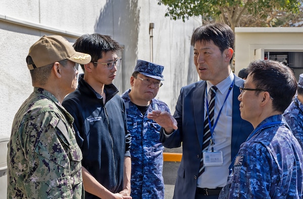 YOKOSUKA, Japan (March 11, 2026) — Eiji Hinoshita, M.D., director general for health and medicine, Japan Ministry of Defense, speaks with Capt. Donavon YapShing, deputy director of U.S. Naval Hospital (USNH) Yokosuka, alongside Japan Maritime Self-Defense Force (JMSDF) personnel during a bilateral mass casualty drill at USNH Yokosuka. The engagement highlighted coordination between USNH Yokosuka and Japanese medical leaders to strengthen interoperability and operational readiness in the Indo-Pacific. USNH Yokosuka and Japan Self-Defense Force (JSDF) Hospital Yokosuka conducted the drill to enhance joint medical response capabilities and lifesaving procedures in support of a free and open Indo-Pacific. (U.S. Navy photo by Daniel Taylor/U.S. Naval Hospital Yokosuka Public Affairs)