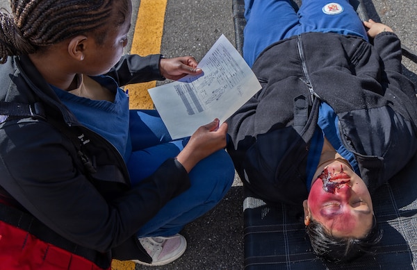 YOKOSUKA, Japan (March 11, 2026) — A U.S. Naval Hospital (USNH) Yokosuka corpsman reviews a casualty assessment form while evaluating a simulated patient during triage operations outside USNH Yokosuka during a bilateral mass casualty drill. The exercise integrated clinical decision-making with documentation and patient tracking procedures.USNH Yokosuka and Japan Self-Defense Force (JSDF) Hospital Yokosuka conducted the drill to enhance joint medical response capabilities and lifesaving procedures in support of a free and open Indo-Pacific. (U.S. Navy photo by Daniel Taylor/U.S. Naval Hospital Yokosuka Public Affairs)