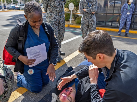 YOKOSUKA, Japan (March 11, 2026) — U.S. Naval Hospital (USNH) Yokosuka personnel coordinate care for a simulated casualty during triage operations outside USNH Yokosuka during a bilateral mass casualty drill. The scenario required rapid communication and joint decision-making to prioritize treatment and evacuation. USNH Yokosuka and Japan Self-Defense Force (JSDF) Hospital Yokosuka conducted the drill to enhance joint medical response capabilities and lifesaving procedures in support of a free and open Indo-Pacific. (U.S. Navy photo by Daniel Taylor/U.S. Naval Hospital Yokosuka Public Affairs)