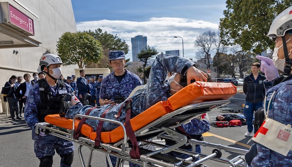 YOKOSUKA, Japan (March 11, 2026) — Japan Maritime Self-Defense Force (JMSDF) responders transport a simulated casualty on a stretcher outside U.S. Naval Hospital (USNH) Yokosuka during a bilateral mass casualty drill. The exercise tested patient movement, coordination, and communication between allied medical teams. USNH Yokosuka and Japan Self-Defense Force (JSDF) Hospital Yokosuka conducted the drill to enhance joint medical response capabilities and lifesaving procedures in support of a free and open Indo-Pacific. (U.S. Navy photo by Daniel Taylor/U.S. Naval Hospital Yokosuka Public Affairs)