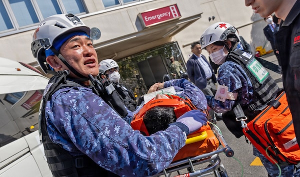 YOKOSUKA, Japan (March 11, 2026) — Japan Self-Defense Force (JSDF) medical personnel transport a simulated casualty on a stretcher during a bilateral mass casualty drill outside U.S. Naval Hospital Yokosuka. The training reinforced lifesaving interventions and teamwork in a dynamic operational setting. USNMRTC Yokosuka and JSDF Hospital Yokosuka conducted the drill to enhance joint medical response capabilities and lifesaving procedures in support of a free and open Indo-Pacific. (U.S. Navy photo by Daniel Taylor/USNMRTC Yokosuka Public Affairs)